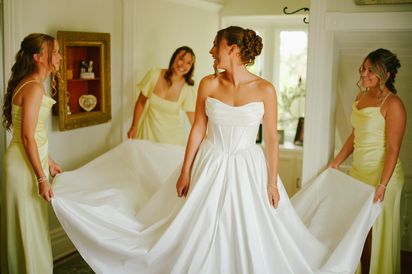 Amy twirl amysmaids holding dress train at Amy and Teddy's North Dakota farm wedding by Megaset Weddings