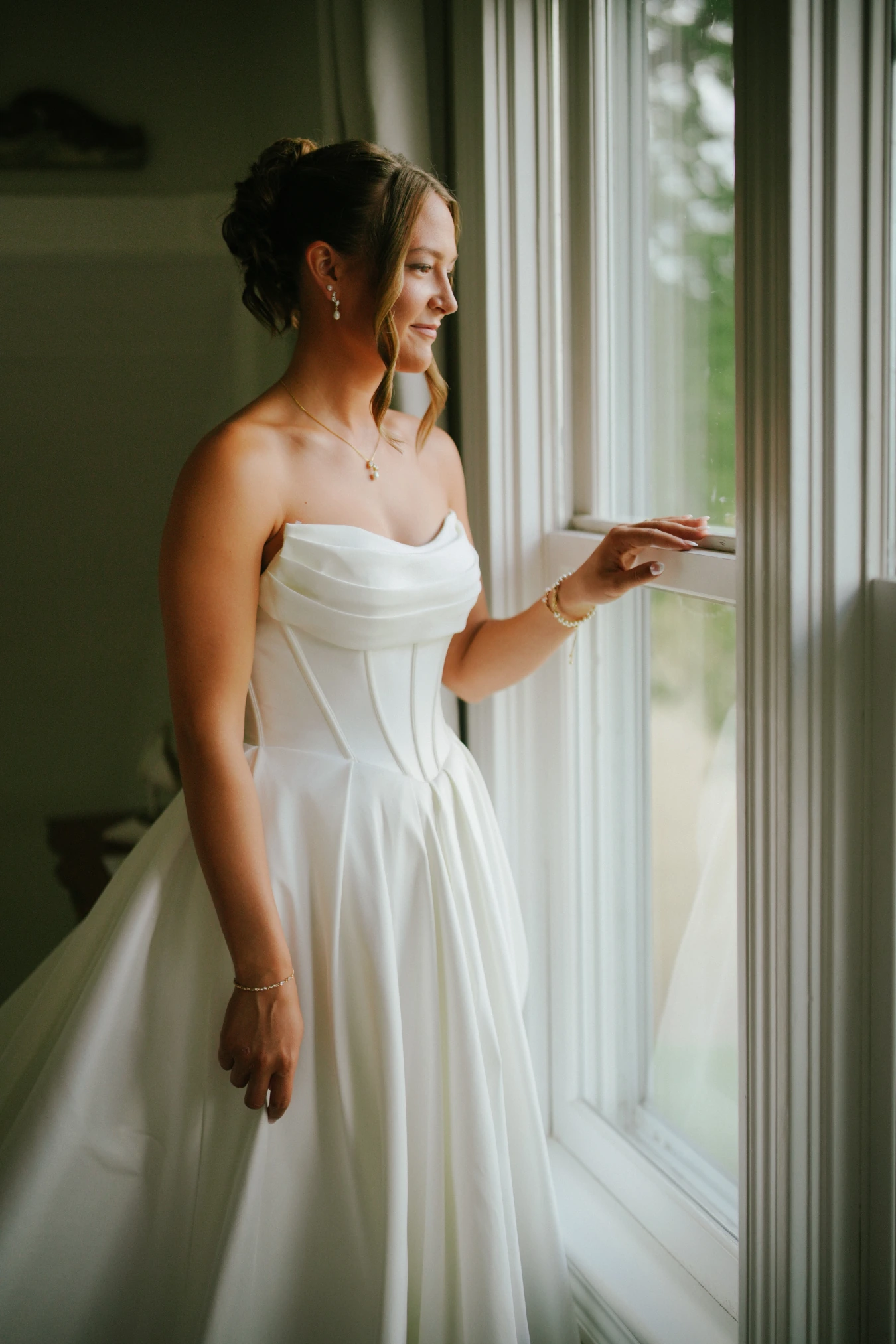 Amy window posing gown at Amy and Teddy's North Dakota farm wedding by Megaset Weddings