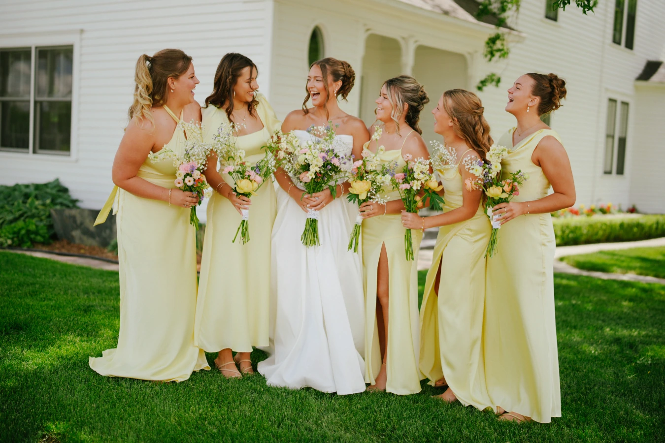Amysmaids yellow dresses bouquets laughing at Amy and Teddy's North Dakota farm wedding by Megaset Weddings