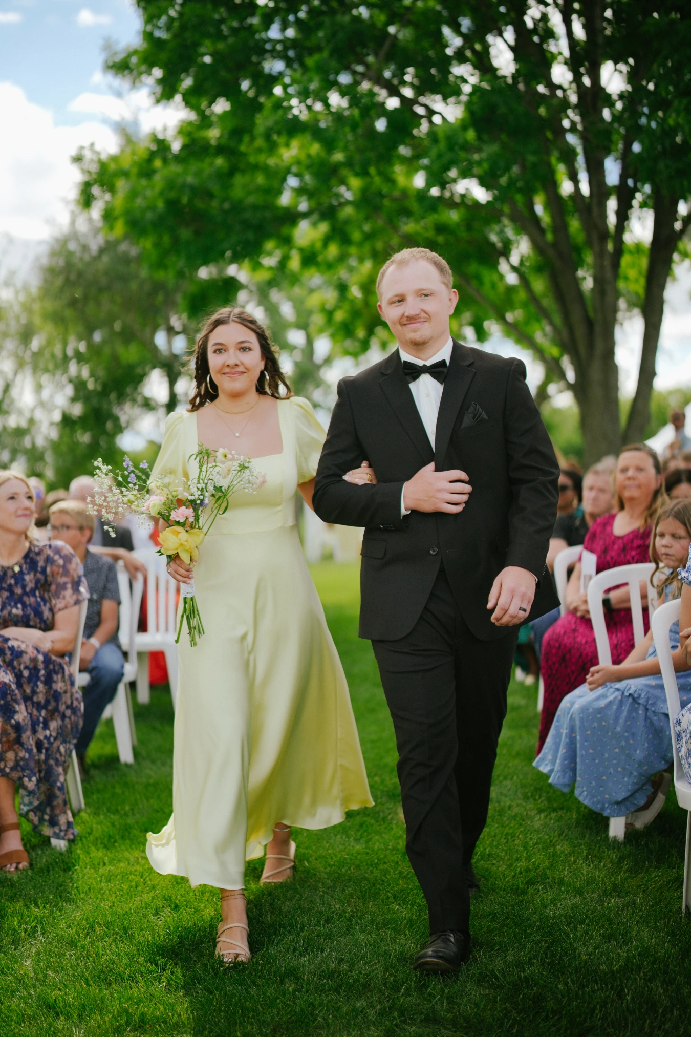 Amysmaid teddysman walking ceremony aisle at Amy and Teddy's North Dakota farm wedding by Megaset Weddings