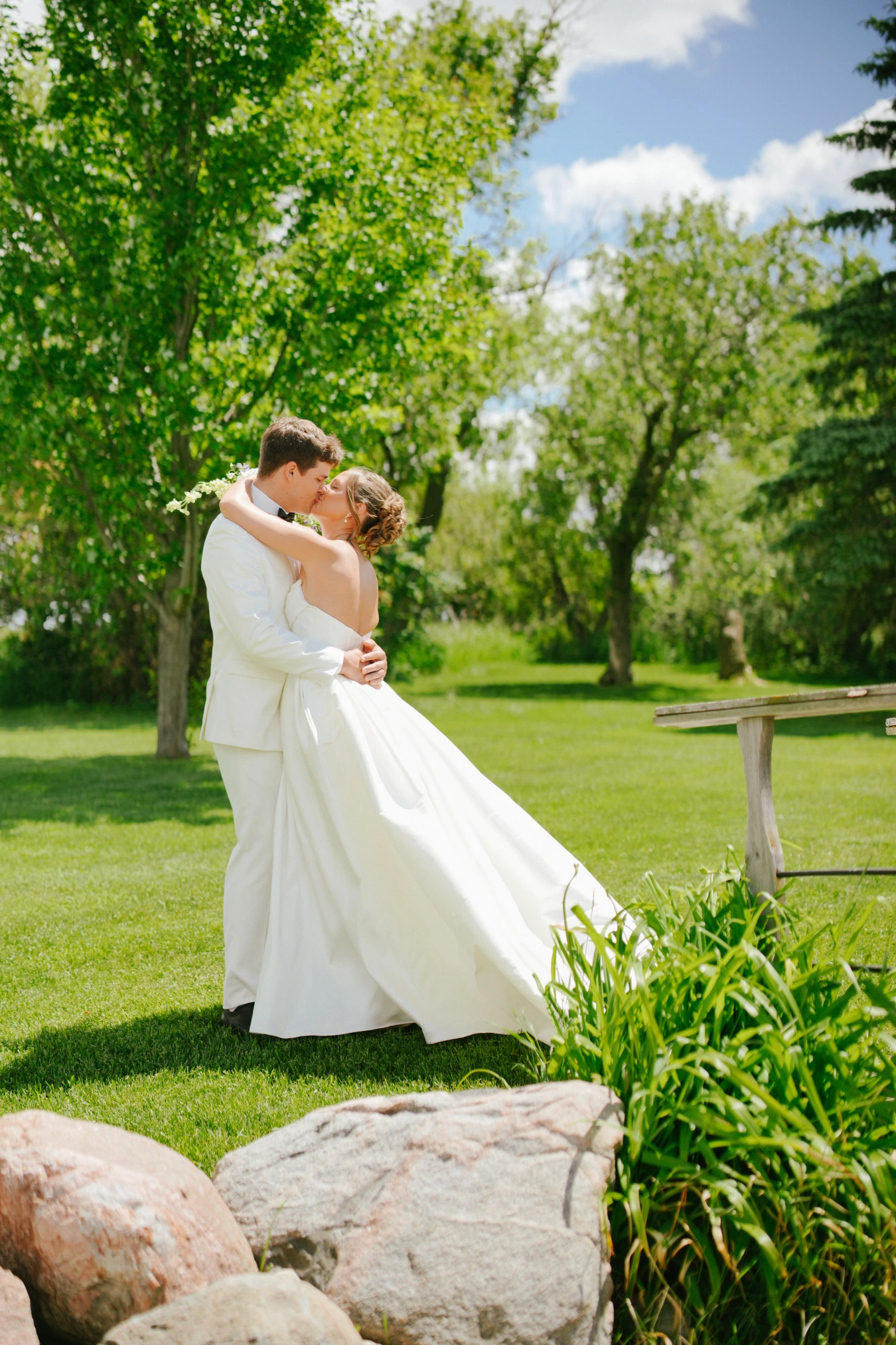 Amy and teddy kissing outdoor at Amy and Teddy's North Dakota farm wedding by Megaset Weddings