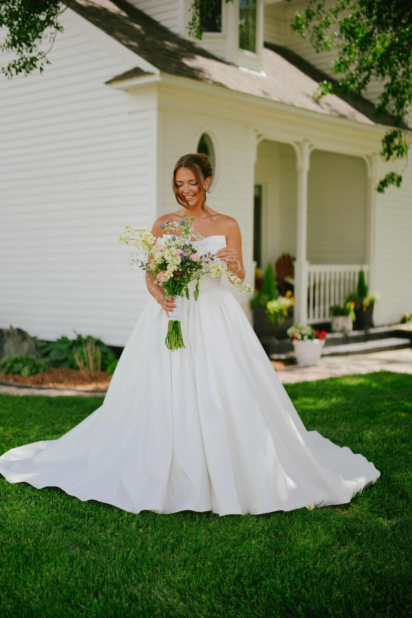 Amy holding bouquet card lawn at Amy and Teddy's North Dakota farm wedding by Megaset Weddings