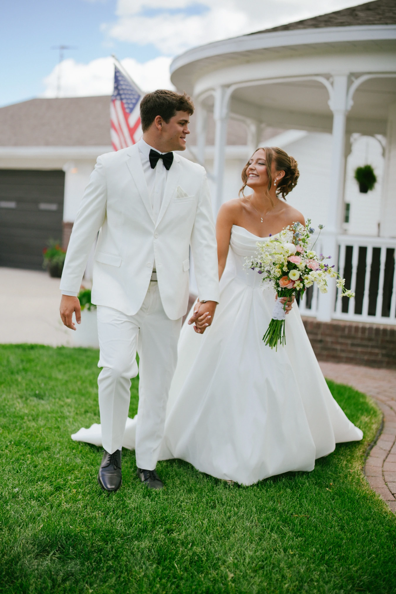 Amy and teddy walking outdoor american flag at Amy and Teddy's North Dakota farm wedding by Megaset Weddings