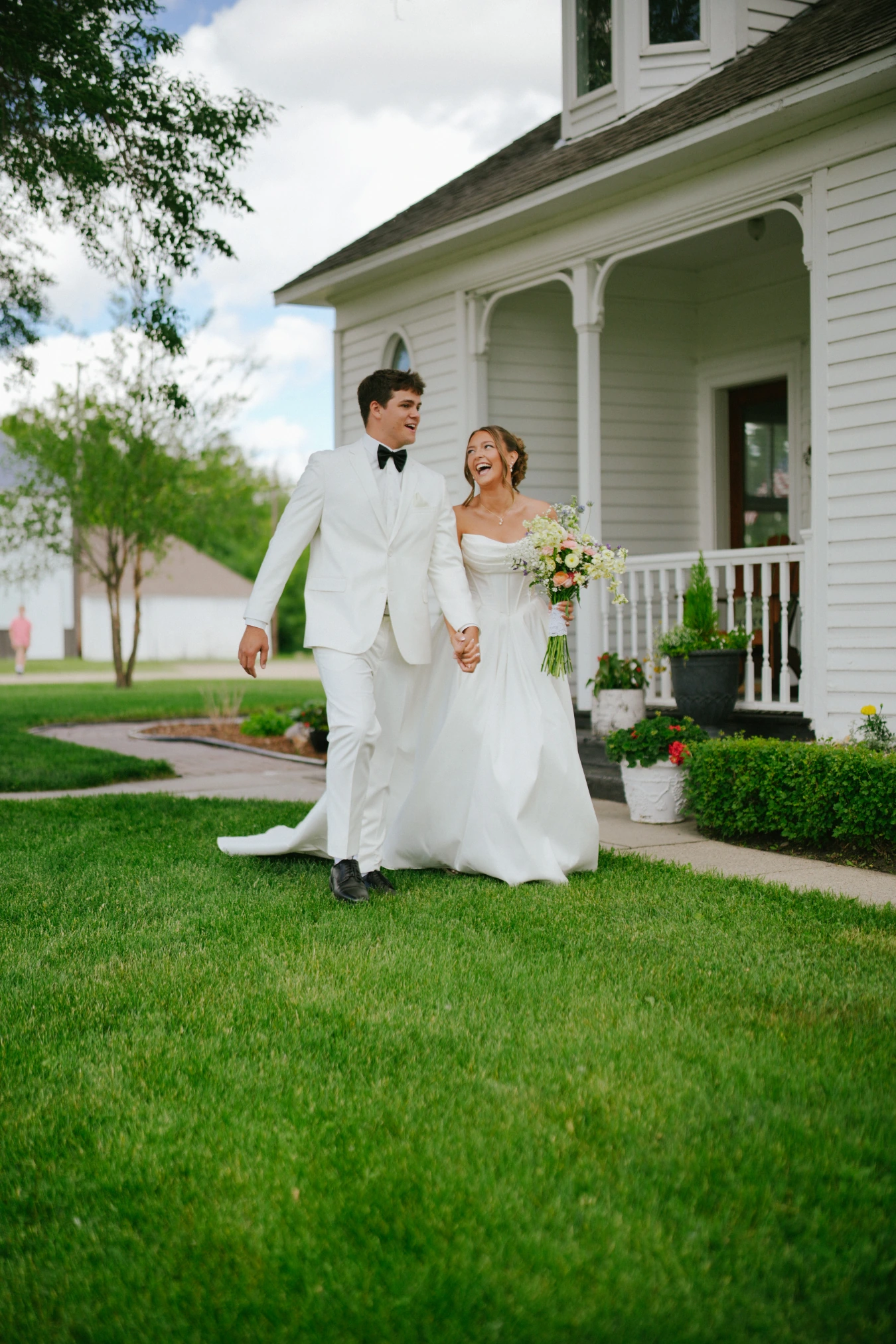 Amy and teddy walking lawn happy at Amy and Teddy's North Dakota farm wedding by Megaset Weddings