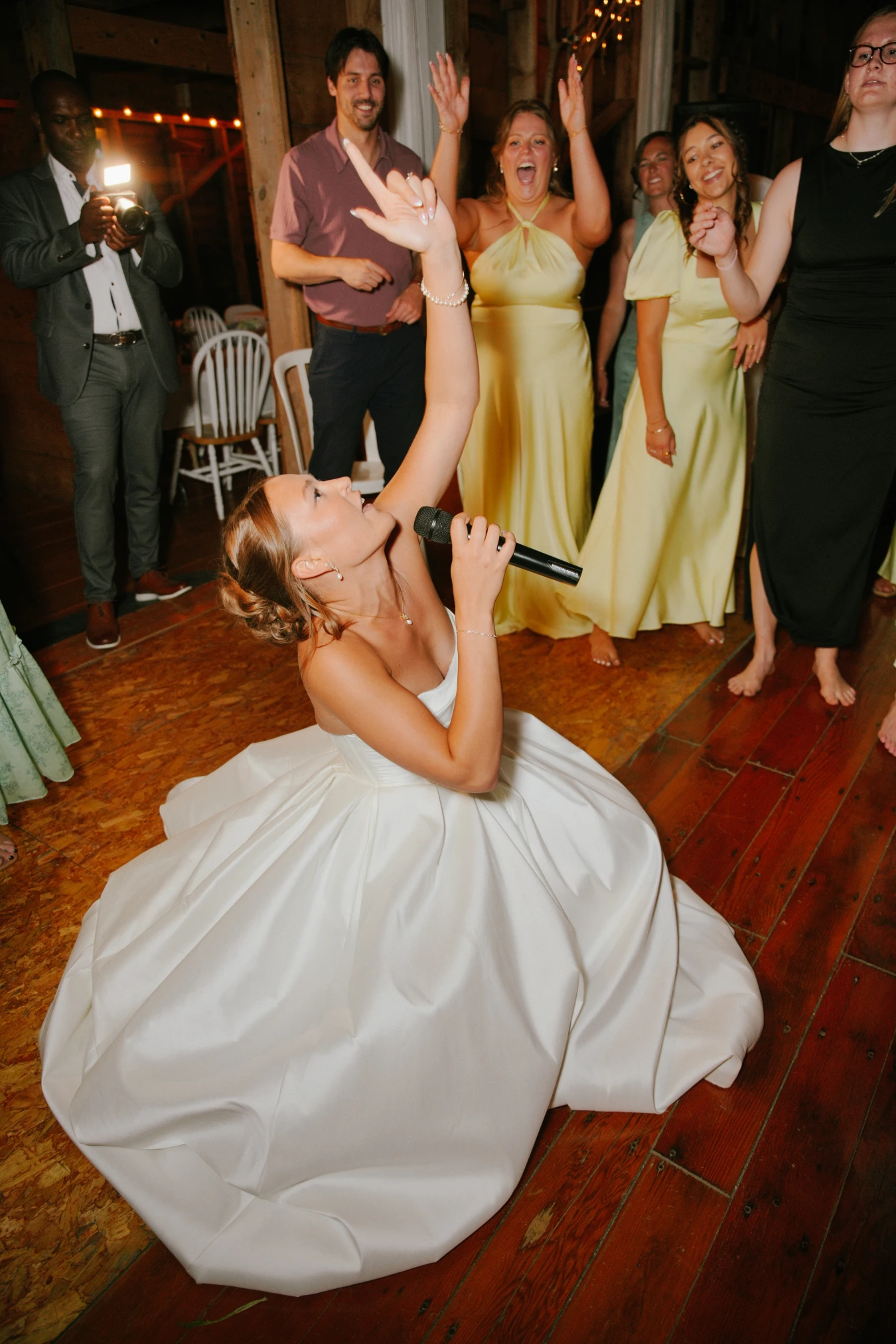 Amy singing microphone reception celebration at Amy and Teddy's North Dakota farm wedding by Megaset Weddings