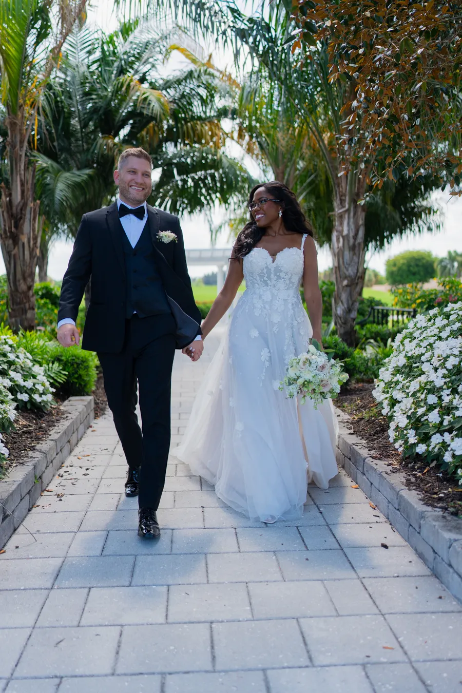 Belinda and Kevin walking together beneath the palms