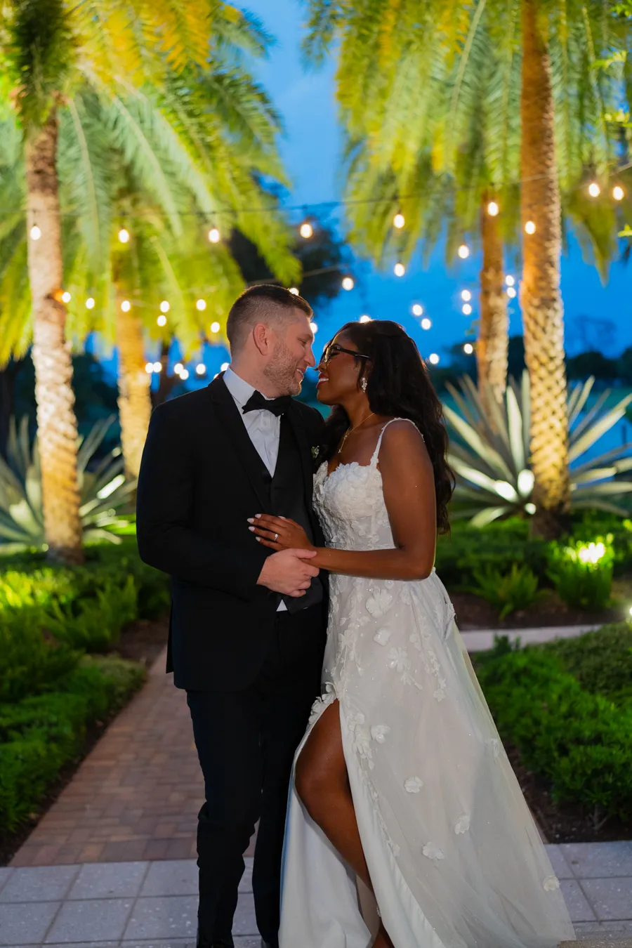 Nighttime couple portrait of Belinda and Kevin under lit palm trees