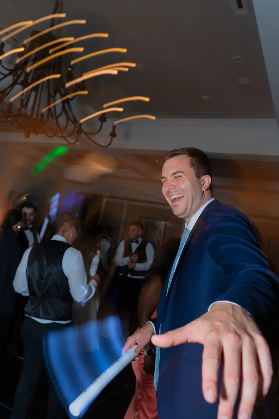 Reception guest dancing closeup with glow sticks