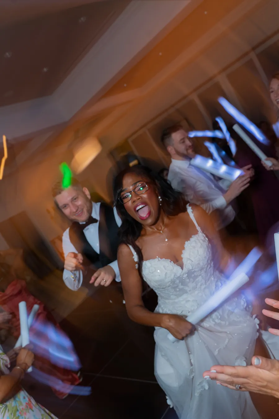 Belinda dancing with glow sticks at the wedding reception