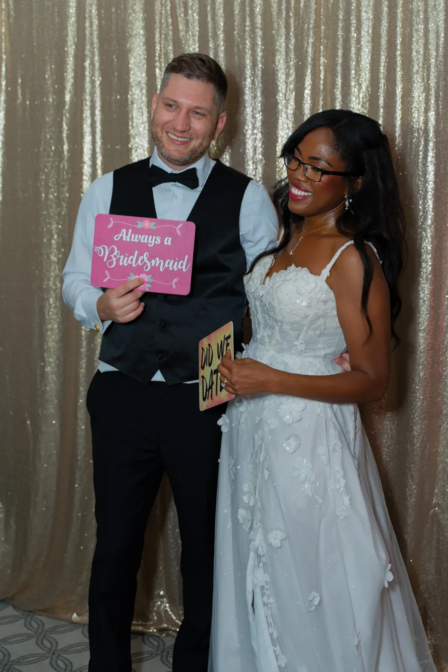 Belinda and Kevin posing with a photo booth sign